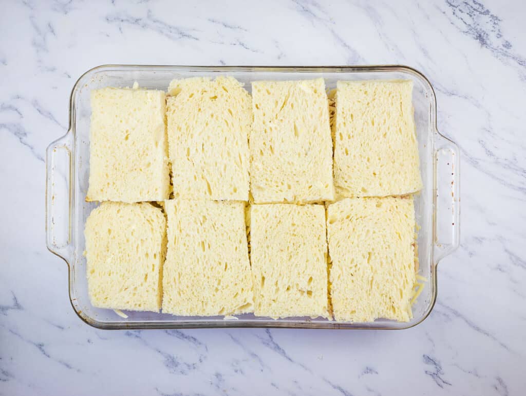 Final layer of bread on the casserole.