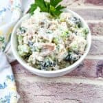 Chicken salad with cranberries and walnuts on a white bowl.