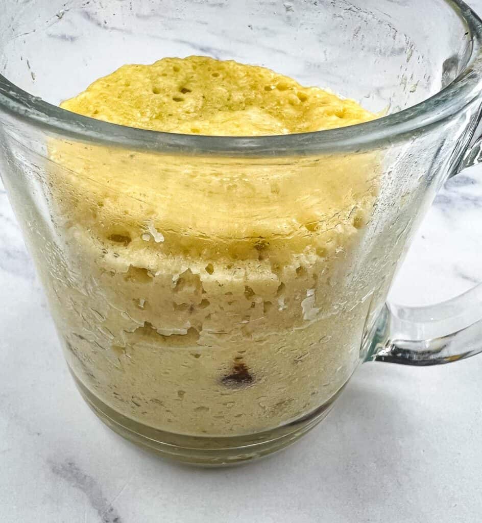 Finished banana chocolate chip mug cake in a mug.