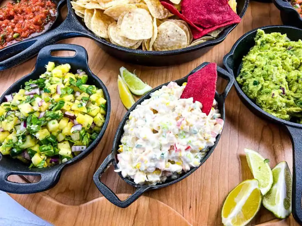 Cold Corn Dip on a snack board with guacamole, chips, and more.