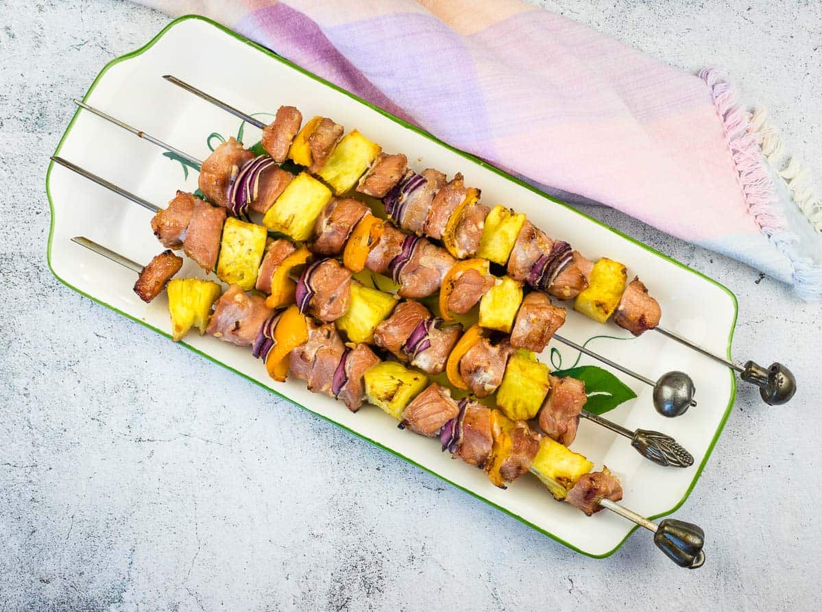 Smoked Pork & Pineapple Kabobs on a plate for serving.