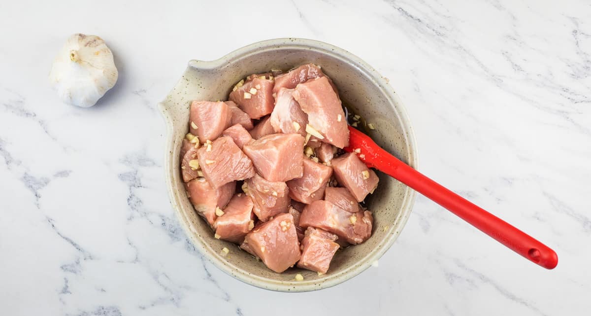Pork and marinade in a bowl.