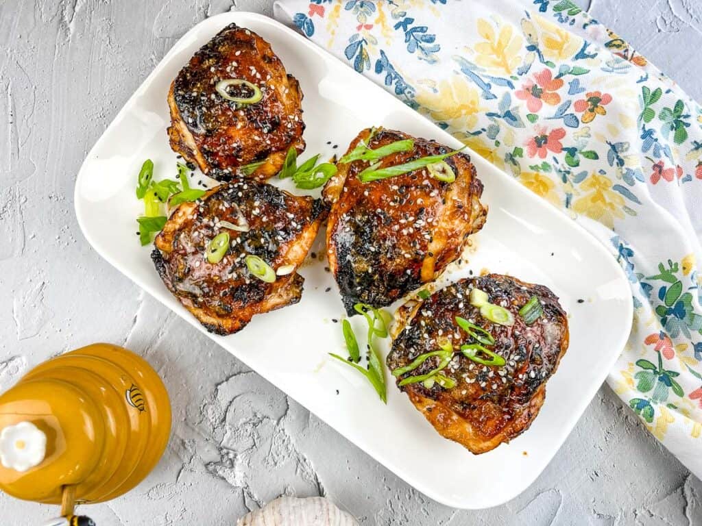 A top-down horizontal image of air fryer honey garlic chicken on a platter.
