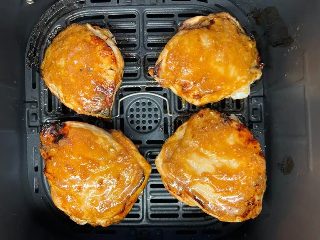 Skin side up chicken in the air fryer basket.