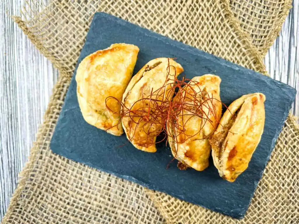 Air fryer empanadas on a slate.