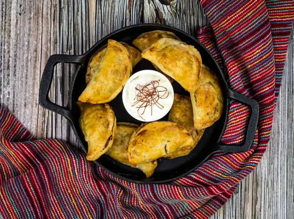 A top-down image of air fryer beef empanadas on a plate.