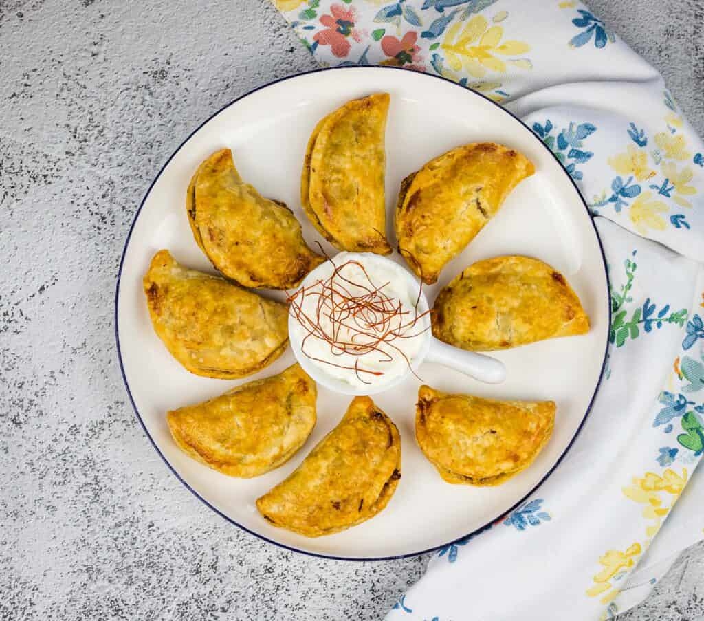 A top-down shot of beef empanadas on a plate.