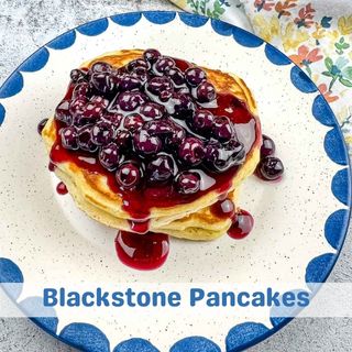 A stack of Blackstone Pancakes topped with blueberry syrup.