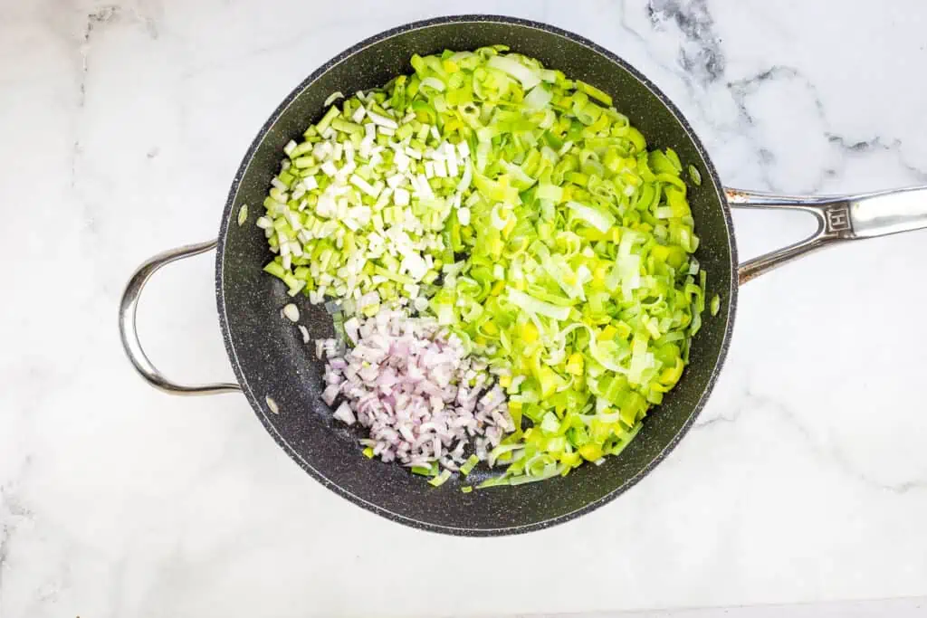 Sautéing the leeks, shallots, and green garlic.