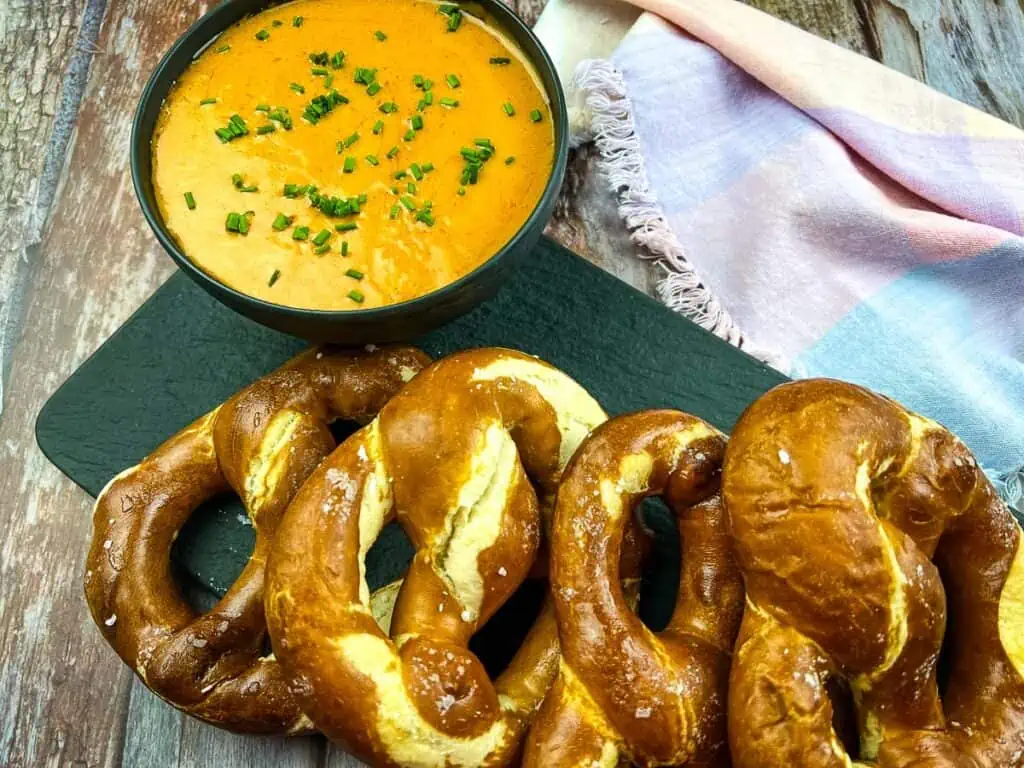 Guinness cheese dip in a black bowl with pretzels.