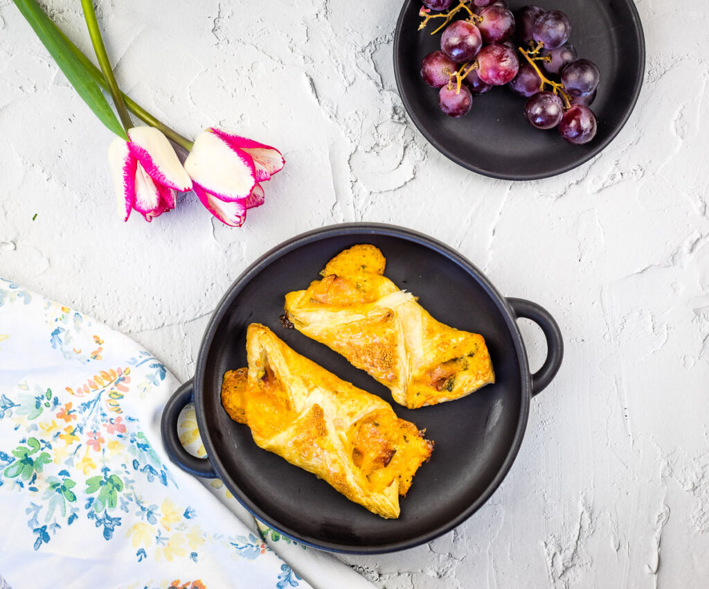 Ham and cheese turnovers on a black plate.