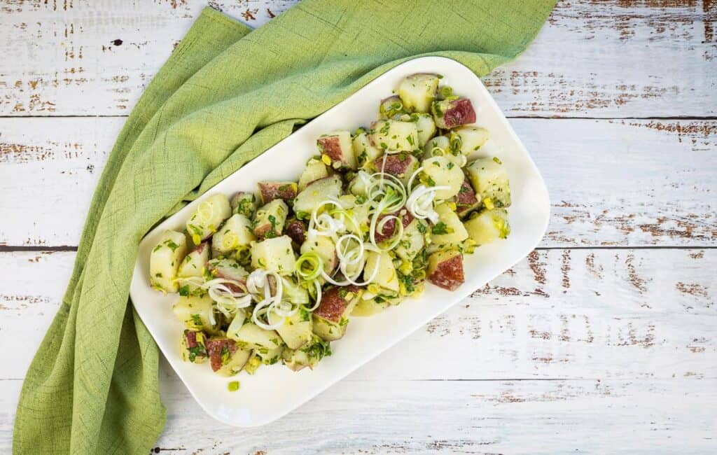 A top-down shot of finished Potato Salad with Herbs and Green Garlic.
