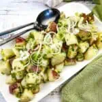 Potato salad with fresh herbs on a white platter.