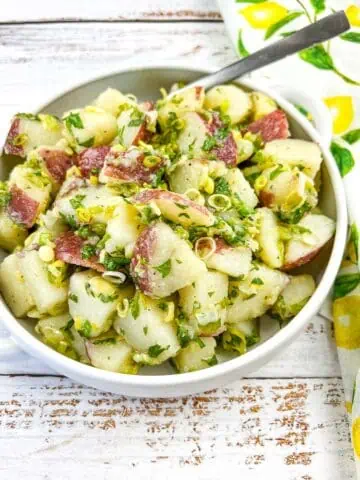 Potato Salad with Herbs & Green Garlic in a white serving bowl.