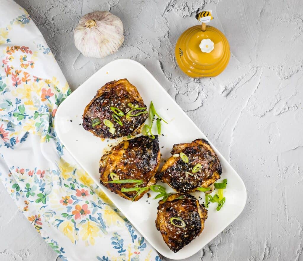 Air fryer Honey Garlic Chicken Thighs on a white plate.