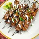 Grilled steak skewers with Mojo Rojo on a plate.