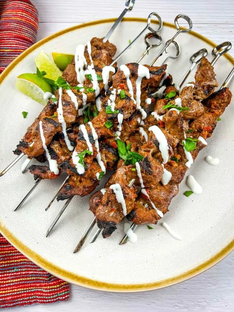 Grilled steak skewers with Mojo Rojo on a plate.