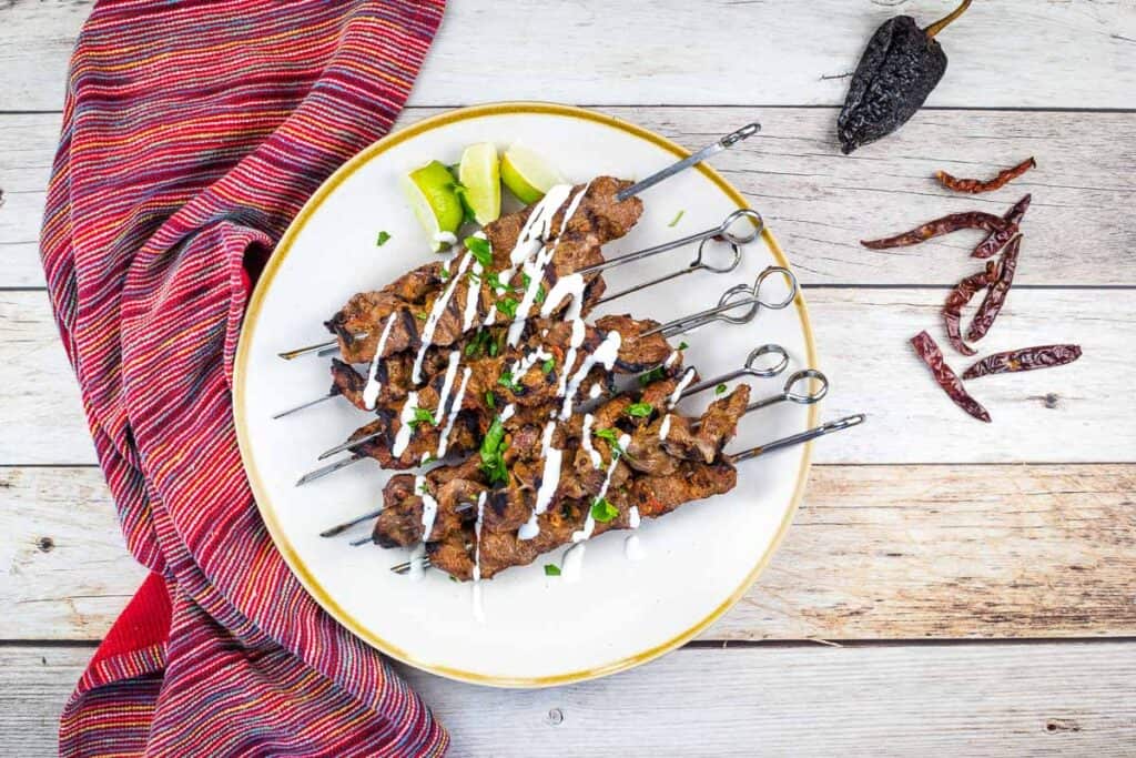 A top-down image of grilled steak skewers on a plate.