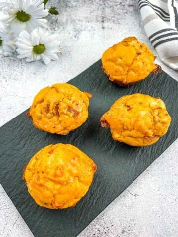 Pizza Muffins on a black plate.