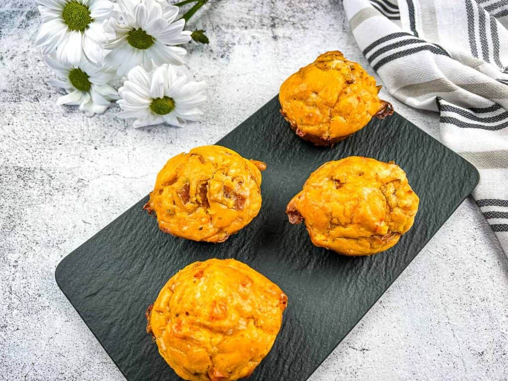 Pizza muffins finished and on a black plate.
