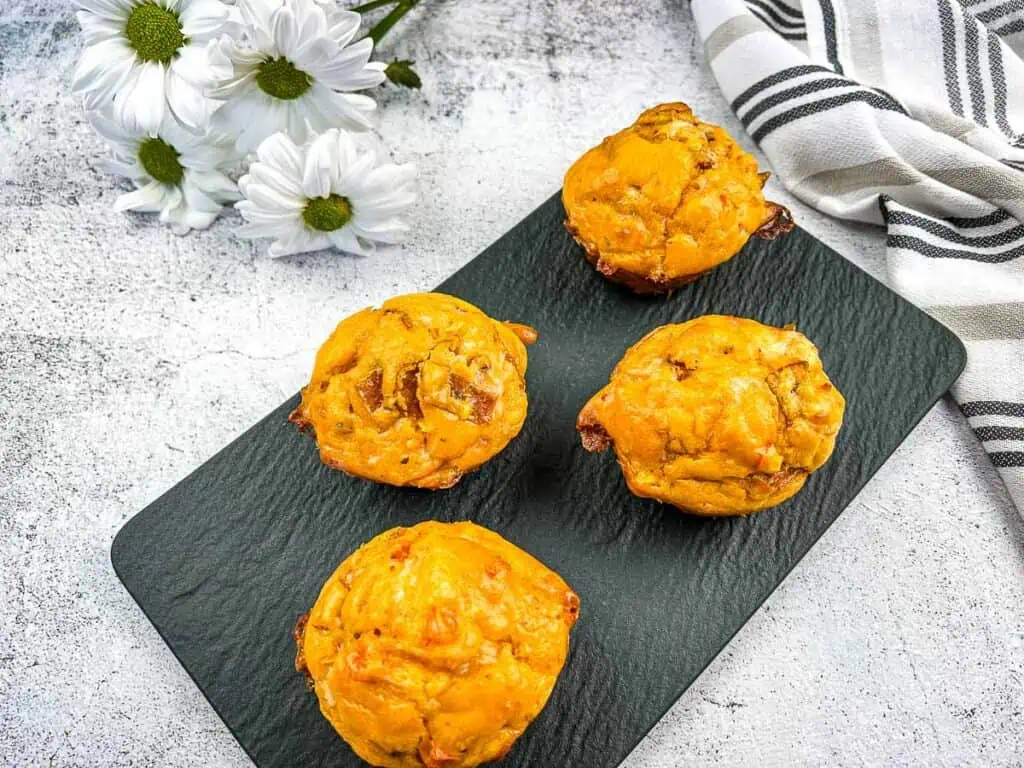 Pizza muffins finished and on a black plate.
