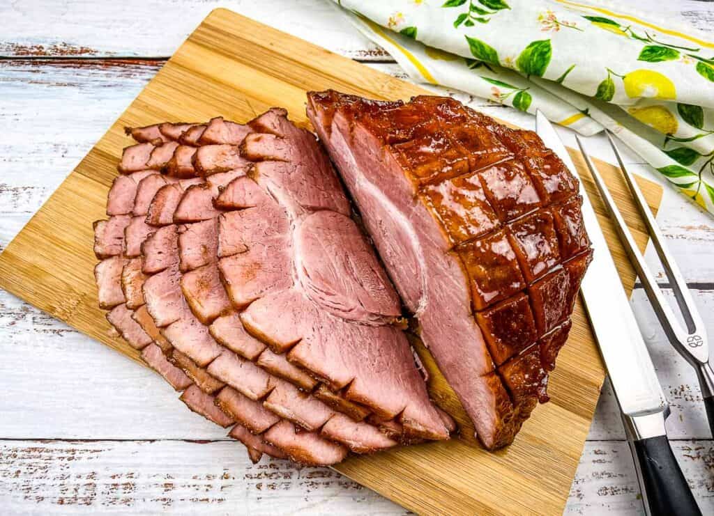 A top-down shot of a sliced Smoked Carver Ham on a cutting board.