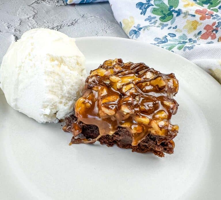 A piece of brownie with ice cream on a plate.