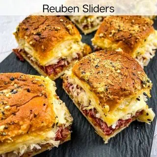 Reuben sliders on a black plate.