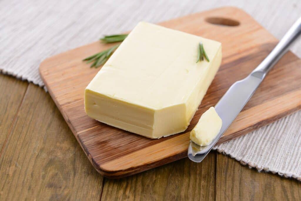 A block of butter with a knife.