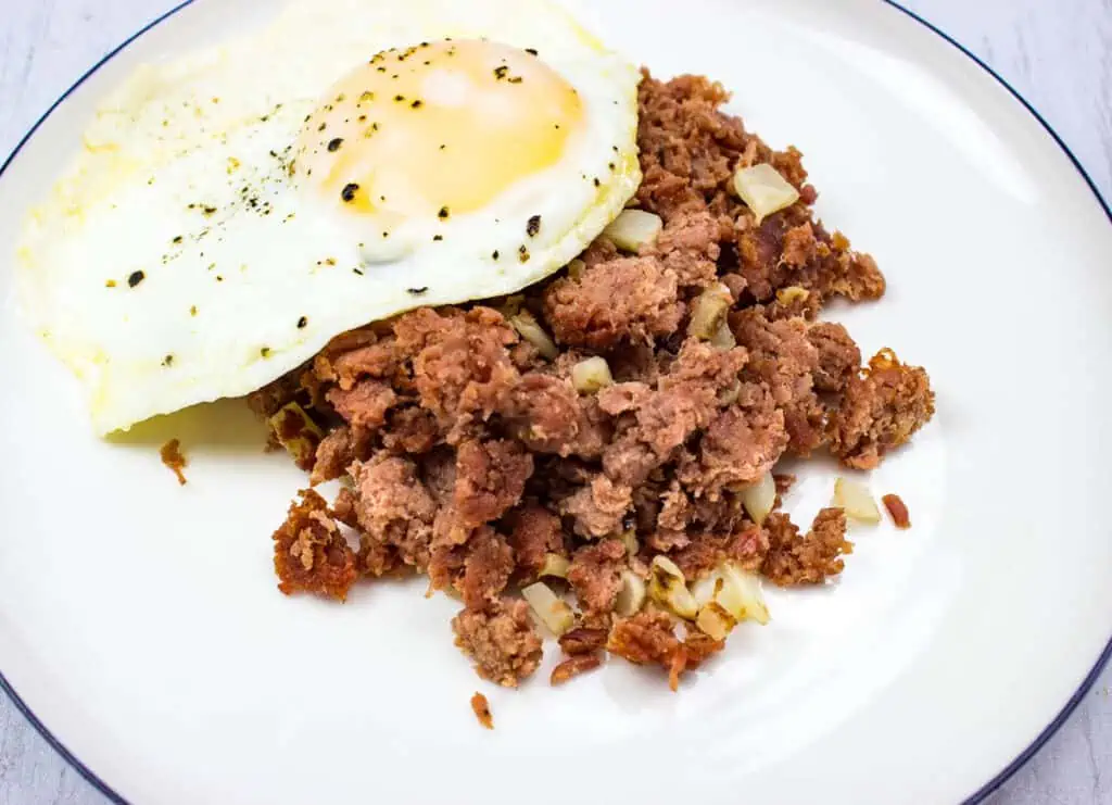 Corned Beef Hash on a plate with an egg.