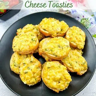 Cheese toasties on a black plate.