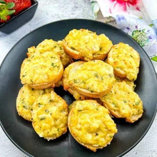 Cheese toasties on a black plate.