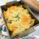 Chicken Florentine Artichoke Bake in a casserole dish with lid nearby.