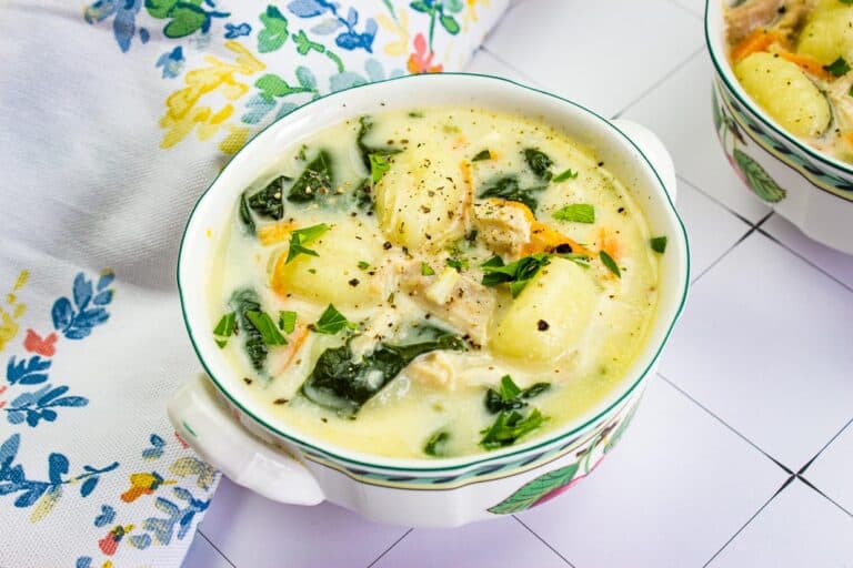 A bowl of chicken gnocchi soup on a table.