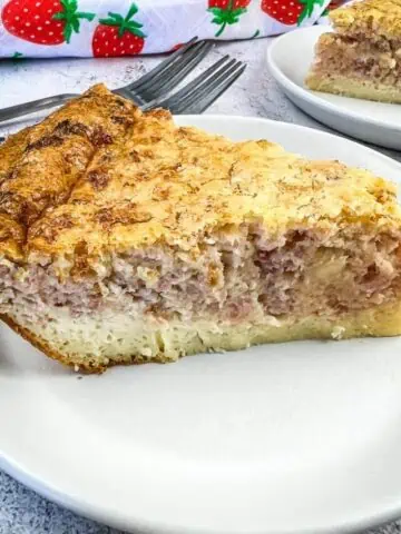 A slice of Ham and Cheese Impossible Quiche with a second slice in the background.