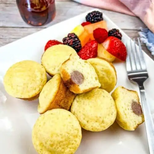 Pancake Bites with Sausage on a plate with fruit.