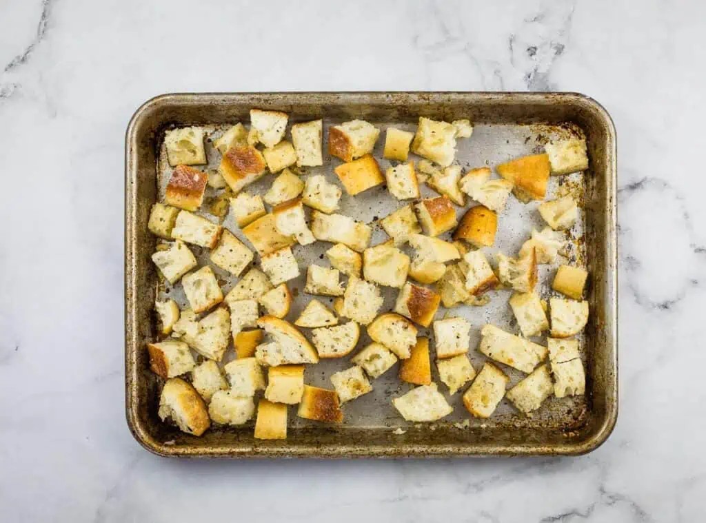 Bread cubes on a baking sheet.