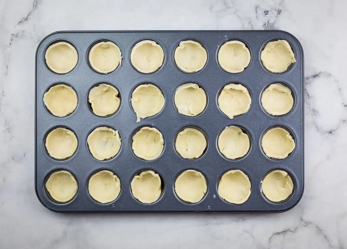 Pastry circles pressed into a mini muffin tin.