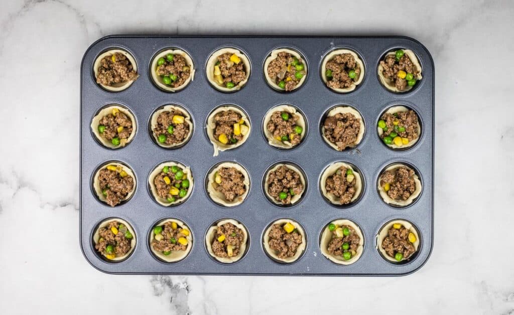 Filling added to the mini muffin tin.