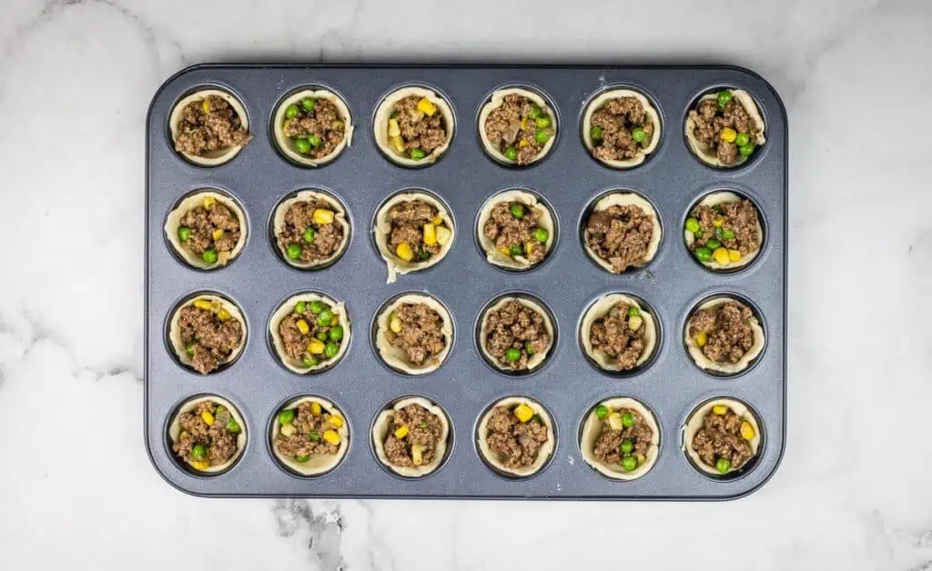 Filling added to the mini muffin tin.