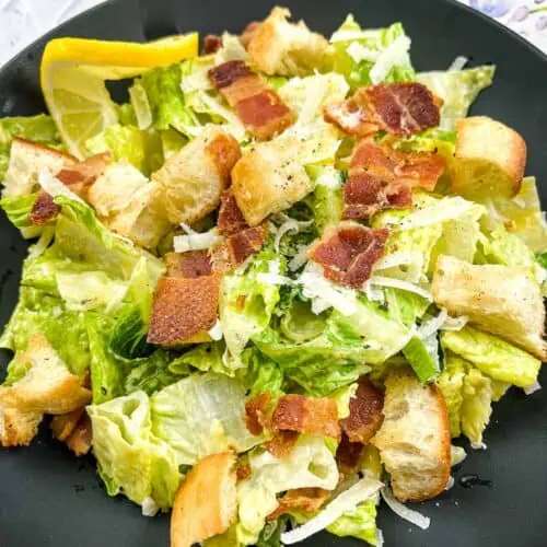 Caesar Salad with homemade dressing in a black bowl.