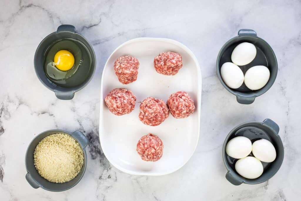 Sausage divided and rolled into balls on a plate.