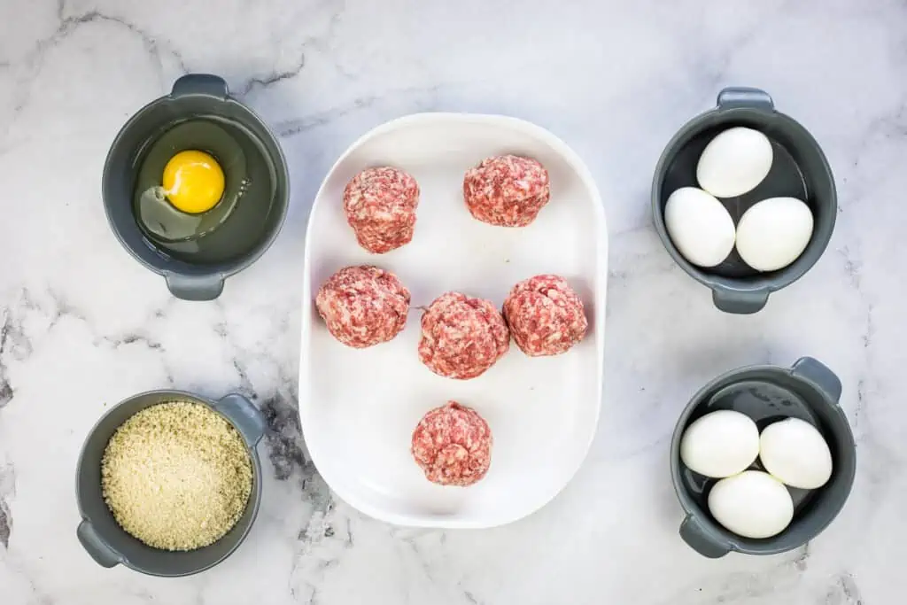 Sausage divided and rolled into balls on a plate.