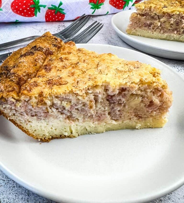 A slice of Ham and Cheese Impossible Quiche with a second slice in the background.