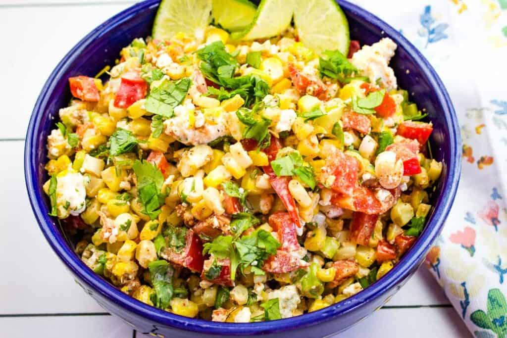 Mexican street corn salad in a blue bowl.