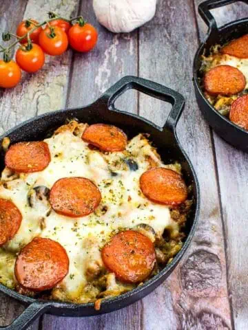 Two servings of pizza casserole in black bowls.