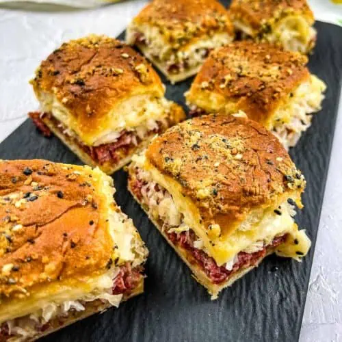 A black platter topped with Reuben Sliders.