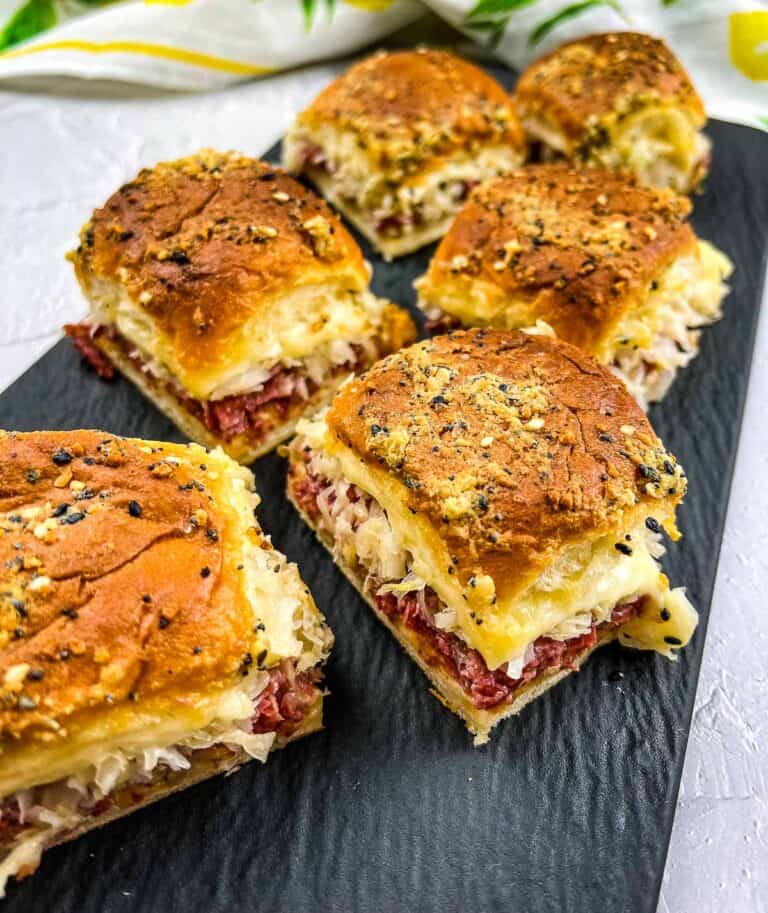 A black platter topped with Reuben Sliders.