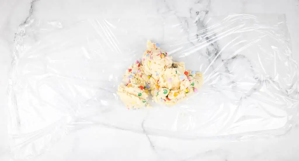 Dough turned out onto plastic wrap.