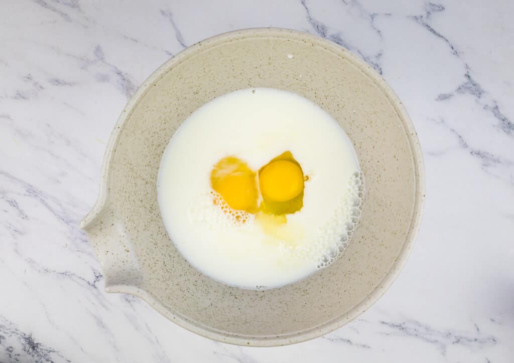 Mixing eggs and milk in a bowl.